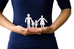 woman holding paper cutouts of her family. 