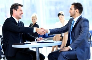 Employer shaking hands with employee signing up for Group Life Insurance