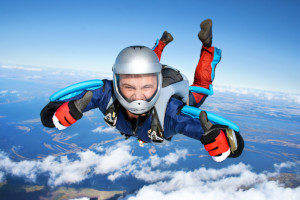 man skydiving and smiling and holding two thumbs up